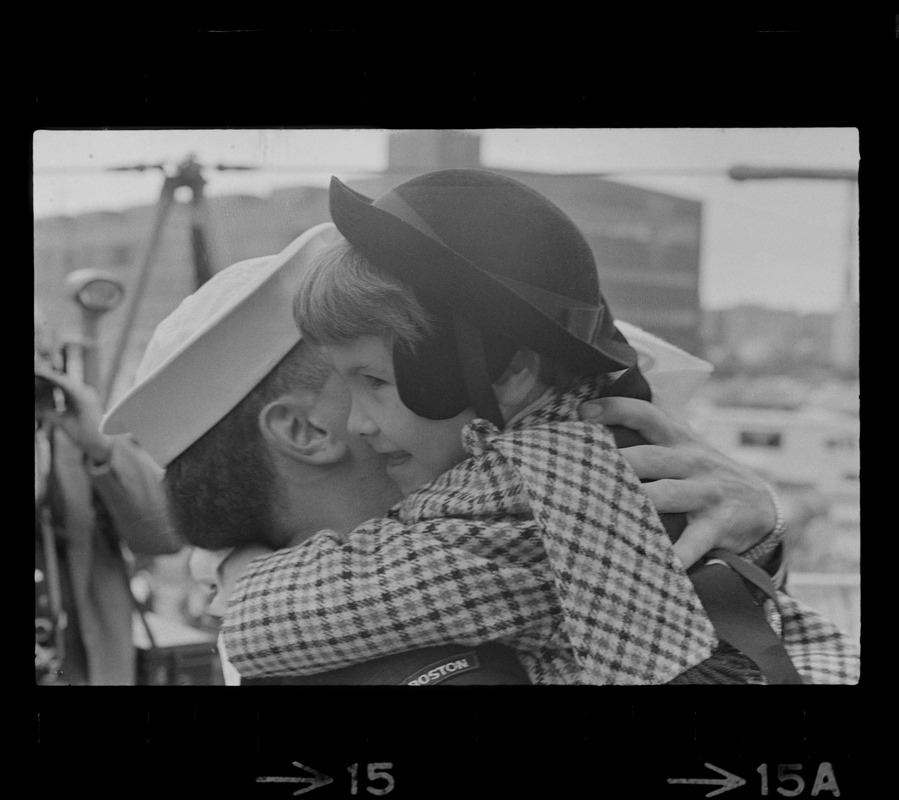 Sailor and child at homecoming of U. S. S. Boston at South Boston Naval Annex