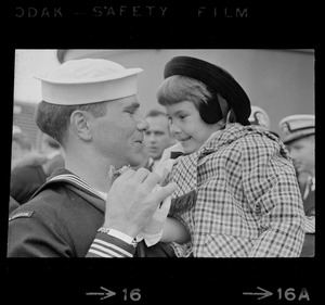 Sailor and child at homecoming of U. S. S. Boston at South Boston Naval Annex