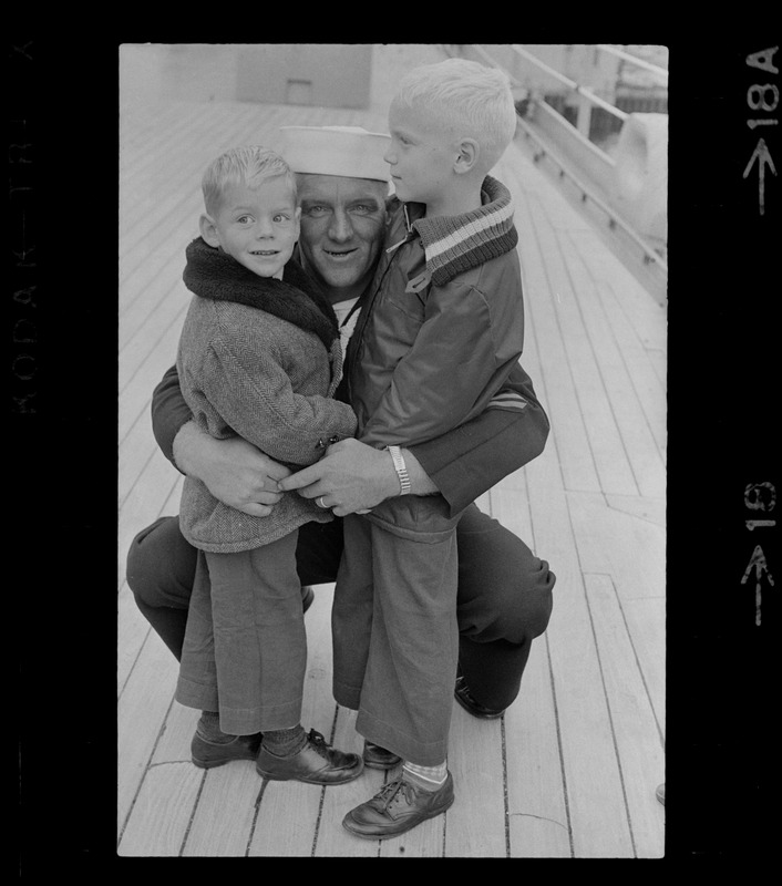 Sailor and children at homecoming of U. S. S. Boston at South Boston Naval Annex