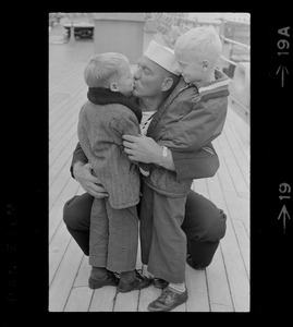 Sailor and children at homecoming of U. S. S. Boston at South Boston Naval Annex