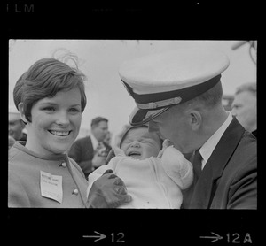 Sailor, woman, and baby at homecoming of U. S. S. Boston at South Boston Naval Annex