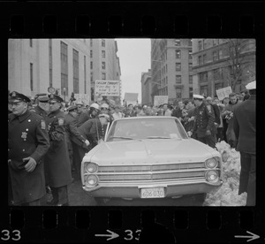Car carrying Dr. Benjamin Spock leaving the Federal Building in Boston after arraignment of "Boston Five" on charges of aiding draft resisters