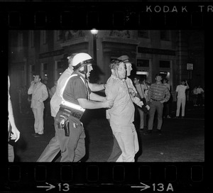 Police lead a bloodied "straight" to the wagon after his arrest for failing to leave Boston Common area when 10 p. m. curfew took effect