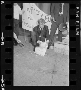 Humphrey supporter with chicken labeled "Chicky-dick alias Tricky Dick" outside Somerset Hotel during Richard Nixon campaign rally