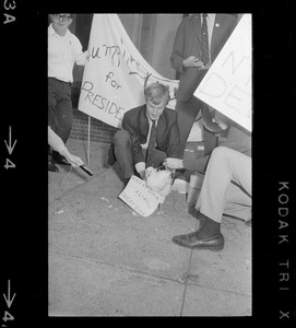Humphrey supporter with chicken labeled "Chicky-dick alias Tricky Dick" outside Somerset Hotel during Richard Nixon campaign rally