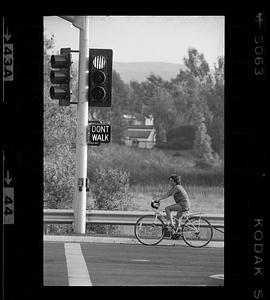 Boy waits on bicycle at street light