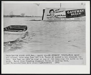 No Swimmin' Today-With water all around, this sign just off U.S. Route 20 looked a bit ironical today. Row boat at left is tied to one of few remaining dry spots in the area. Water from flooding Missouri River is causing this.