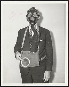 T. A. O’Leary of Pittsburgh shown in the gas mask, with talking equipment attached, which he invented for persons who must talk while wearing masks as protection against fumes. O’Leary is pointing to the opening from which the wearer’s voice comes.