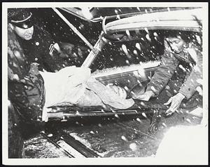 Roxbury man injured during storm is carried into City Hospital by police and hospital aide. Man, Hollis Maupin, 22, of Bower St. was treated for superficial cuts.