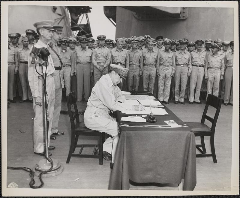 Douglas MacArthur signs as the Supreme Allied Commander during formal ...