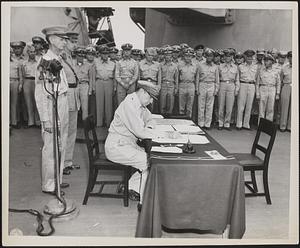 Douglas MacArthur signs as the Supreme Allied Commander during formal surrender ceremonies on the U.S.S. Missouri in Tokyo Bay