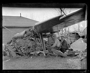 Two people by a wrecked airplane