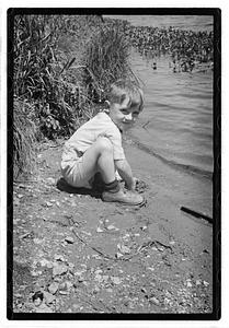 Boy by a body of water