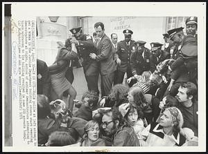 In or Out--While police at left attempt to get a woman in the Justice Department building others start removing demonstrators at right. Action of antiwar demonstrators attempting to block entrances to the building resulted in some 200 arrests today.