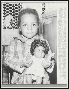 Two-year-old Traci Peraza holds "Baby Nancy," a 13-inch-high toy that went on sale at the Black Doll Toy Co. in South-Central Los Angeles 11/15. According to one of the co-owners of the retail store, Robert Welsh, this is the first such toy made by black people in a black community. The doll is being produced by the Shindana Toy Factory, which was equipped and initially financed by Mattel, Inc. and later turned over to operation "Bootstrap," a self-held training and business launching facility