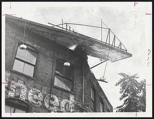 Victim of advance winds which hit Boston ahead of Hurricane Esther was this sign toppled on roof of building at 283 Tremont St., South End.