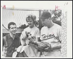 Twins Set for Spring Training -- Mrs. Billy Martin holds pet dog, Bebe, who's trying to take a nip out of baseball held by Minnesota Twins' outfielder Jim Lemon at the club's spring training camp at Orlando today. Lemon and Billy Martin, left, were among early arrivals at the Twins' training camp.