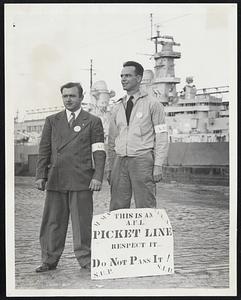 Picketers Cover the Waterfront - Herbert M. White (left) and Eugene Hanot, carry picket signs advertising the strike of the AFL Seafarers International Union. The battleship Missouri is in the background.