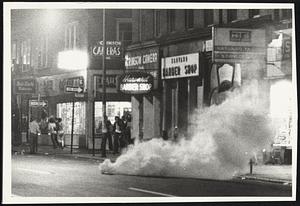 Young folks hide from tear gas on Mass Ave.