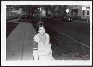 Boy standing on the sidewalk and smiling