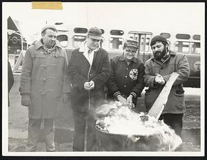 The Only source of warmth for these GE pickets is a fire in a barrel.
