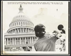 An antiwar protestor throws his medals over a fence in front of the Capitol 4/23 as part of the Vietnam Veterans Against the War demonstration.