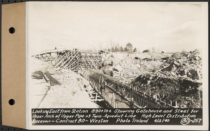 Contract No. 80, High Level Distribution Reservoir, Weston, looking east from Sta. 890+70+/- showing gatehouse and steel for upper arch of upper pipe of twin aqueduct line, high level distribution reservoir, Weston, Mass., Apr. 2, 1940