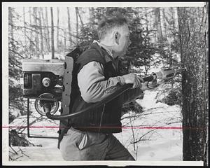 Tap Trees-Harold Eastman uses a power-driven tree tapper as he drills holes in trees on his Quechee, Vt., farm as cold nights and warm days usher in the sap-running season. With this method the tapping of trees may be done in a rapid-fire manner.