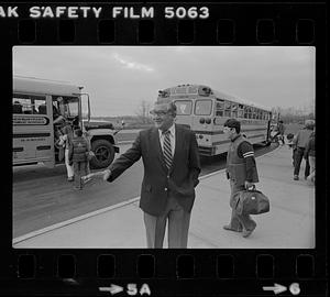 Peter Matthews near school buses and students