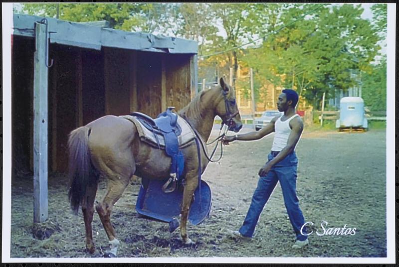 Charles Jackson with his horse Trigger in front of hay shelter