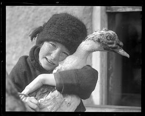 A girl holds a duck