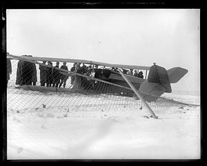 People surrounding a Pitcairn Mailwing wrecked in the snow