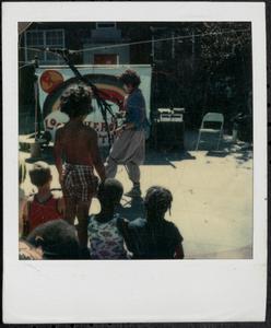 Young person performing for children, possibly a clown