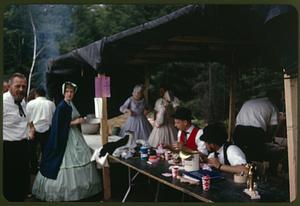 People in period dress helping at a food tent during the antique car rally BBQ