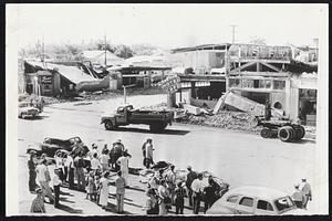 Rubble Fills the sidewalks [illegible] into the streets at this main intersection in Tehachapi, Calif., after a severe earthquake killed at least 11 and injured a score or more. Nearly every building in the three blocks business section was damaged, most of them severly.