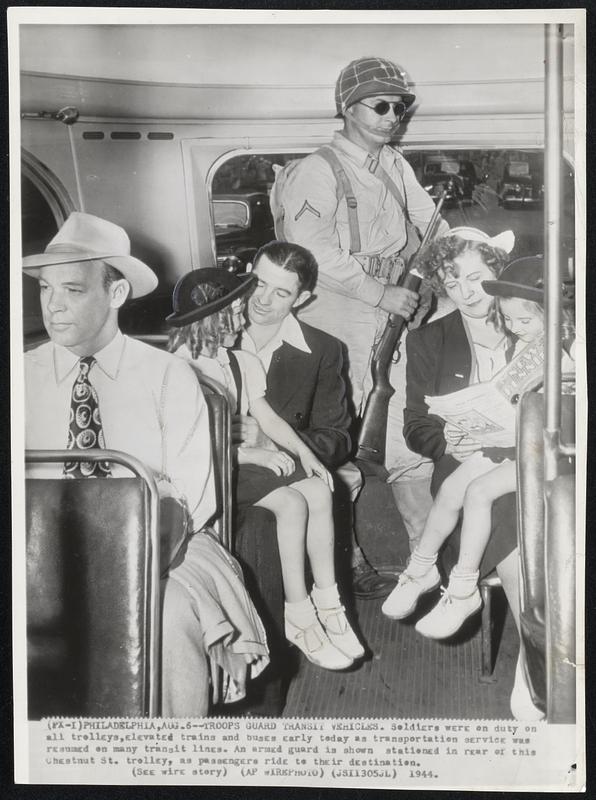 Troops Guard Transit Vehicles. Soldiers were on duty on all trolleys, elevated trains and buses early today as transportation service was resumed on many transit lines. An armed guard is shown stationed in rear of this Chestnut St. trolley, as passengers ride to their destination.