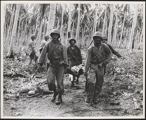 Corpsmen bring back a wounded Marine while under heavy sniper fire on Guadalcanal