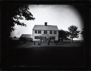 People posed in front of a farmhouse
