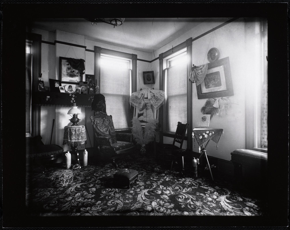 Interior room with family photographs, shells, feathers, and jugs