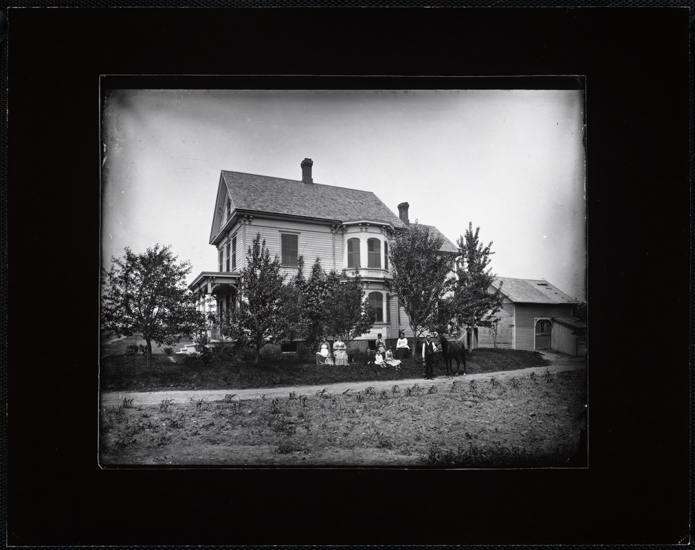 A large family group posed outside an Italianate farmhouse