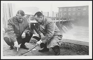 Taunton Police Chief John Bobola (Rgt) draws diagram on ground for Lt. Gov. Sargent at site of Mill Dam