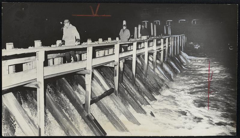 Army Engineers Inspect threatened Whittenton Mill Dam as high waters cascade over brink. They were checking pressure on structure and timbers.