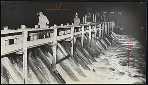 Army Engineers Inspect threatened Whittenton Mill Dam as high waters cascade over brink. They were checking pressure on structure and timbers.