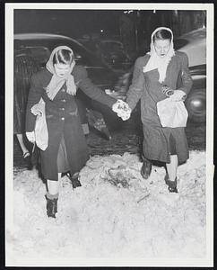 Watch Your Step--these two young ladies give each other a hand as they tackle the slush and snow during yesterday's storm in downtown Boston.