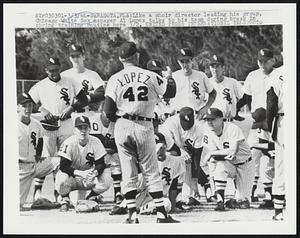 Like a choir director leading his group, Chicago White Sox manager Al Lopez talks to his team during break in spring training routine here 3/2.