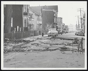 Fierce Gales and icy weather hit New England yesterday, causing heavy damage. Right, debris of broken limbs strews Leyden street, East Boston.
