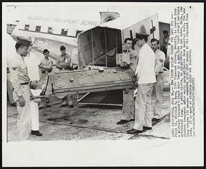 New Light Weight 'Lung' Put Into Use- First Lt. William H. Owen, 1544 Vinewood street, Detroit, is leaded into a military transport plane here today in a new type light weight portable artificial lung. a polio victim, he is en route to Ann Arbor, Mich., for further treatment after early care at Walter Reed hospital here. The new lung weighs 150 pounds compared with 1800 pounds of the standard iron lung. It is made of aluminum alloy and plastics.
