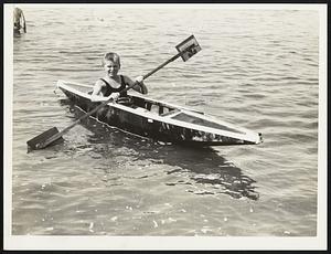 Howard Tinney, age 11, of 32 Daniel St., Hopedale, Mass in the home made kayak which he and his friends made themselves. It was built purposely to tilt to one side. He is giving it its first tryout at Wollaston beach.