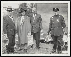 Raiders and Seized Alcohol- Revere investigators, seeking sources of poison liquor, are shown with some suspected contraband. Left to right: Chief Colin W. Gillis, Sgt. Carlton Campbell, Inspector Michael J. Foley and Patrolman John Felt.
