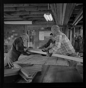 Pert Lowell and others working in boat shop